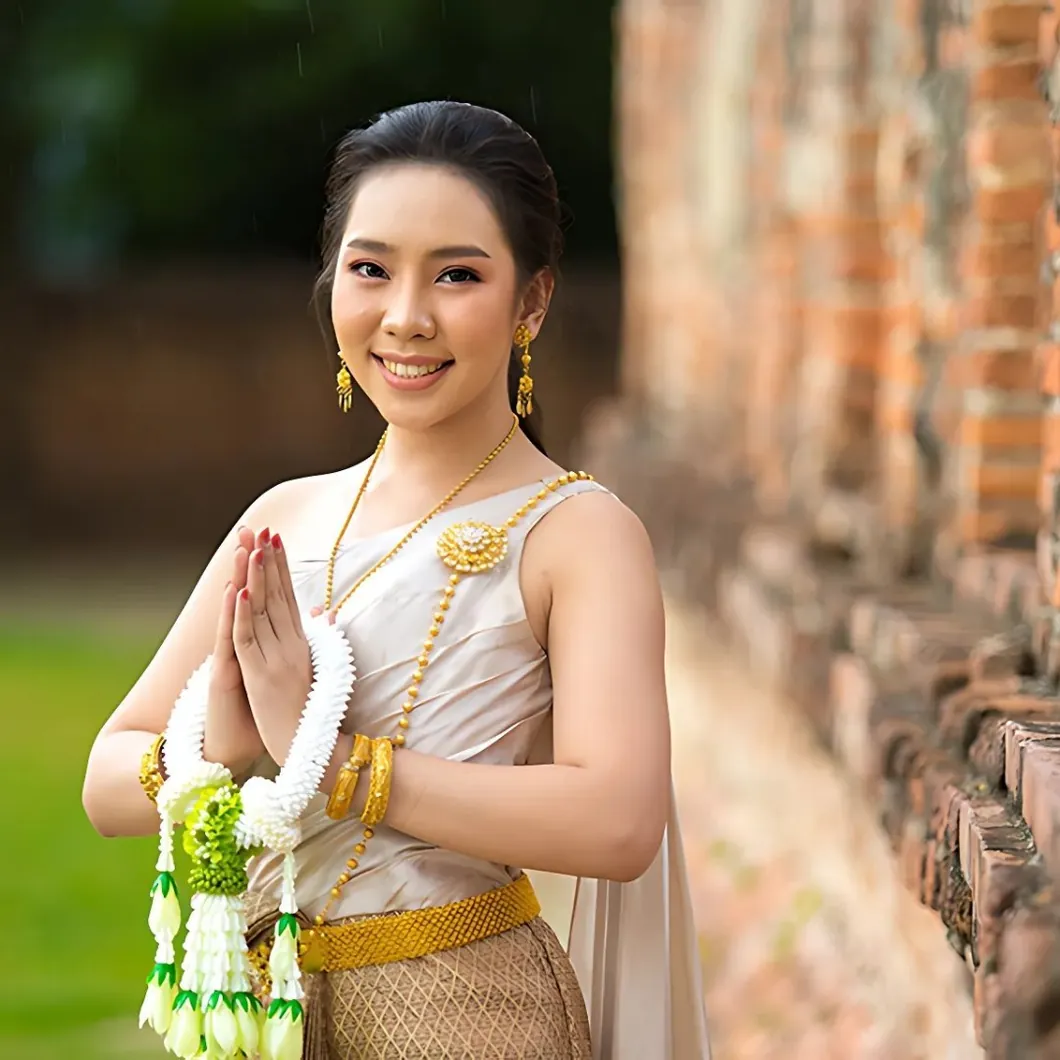 Femme thaïlandaise en tenue traditionnelle faisant le wai