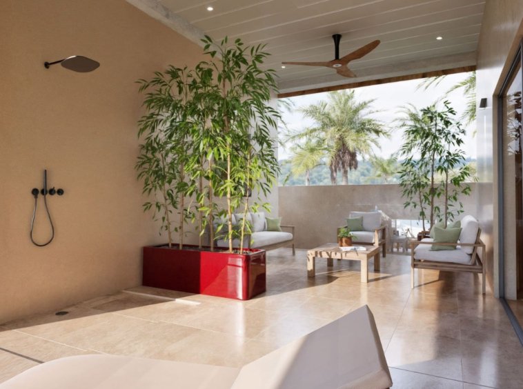 Douche extérieure villa Koh Samui – espace semi-ouvert avec bambous, salon lounge et vue sur palmiers tropicaux