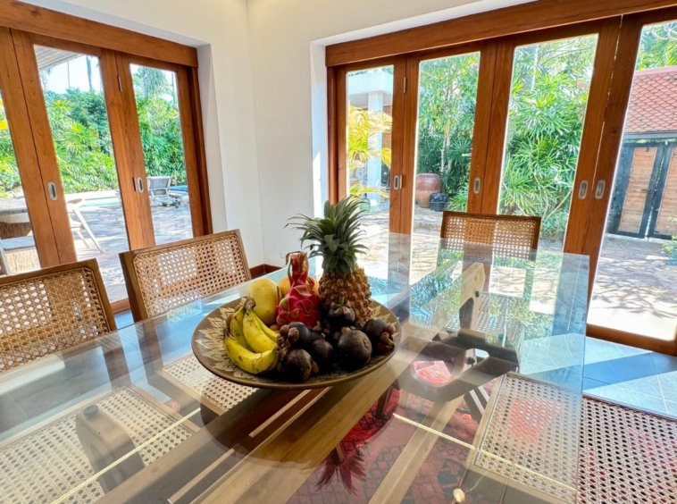 Table à manger plateau verre coupe de fruits tropicaux fenêtres bois villa Samui