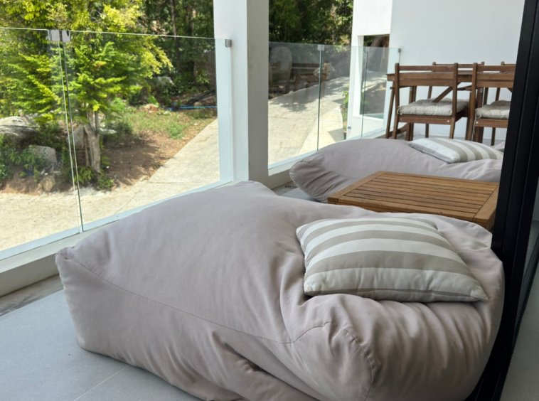 Espace détente terrasse bean bags table teck vue rochers végétation appartement Samui
