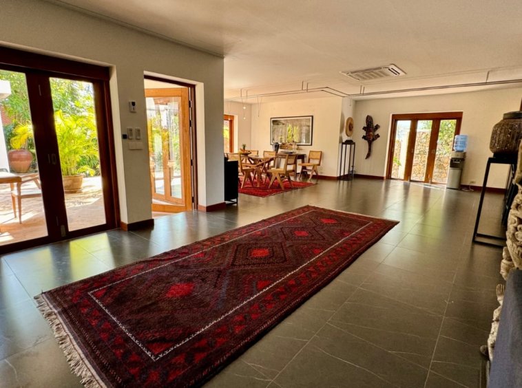 Vaste séjour tapis persan rouge statues asiatiques décoration villa Koh Samui