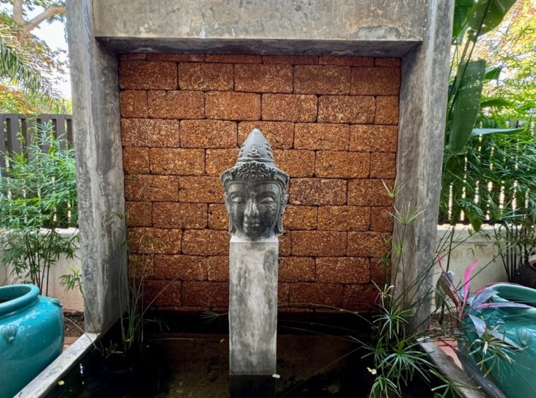 Fontaine jardin tête Bouddha pierre briques latérite bambou villa Samui