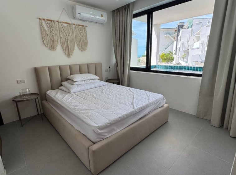 Chambre lumineuse macramé fenêtre vue piscine résidence lit capitonné Emerald Samui