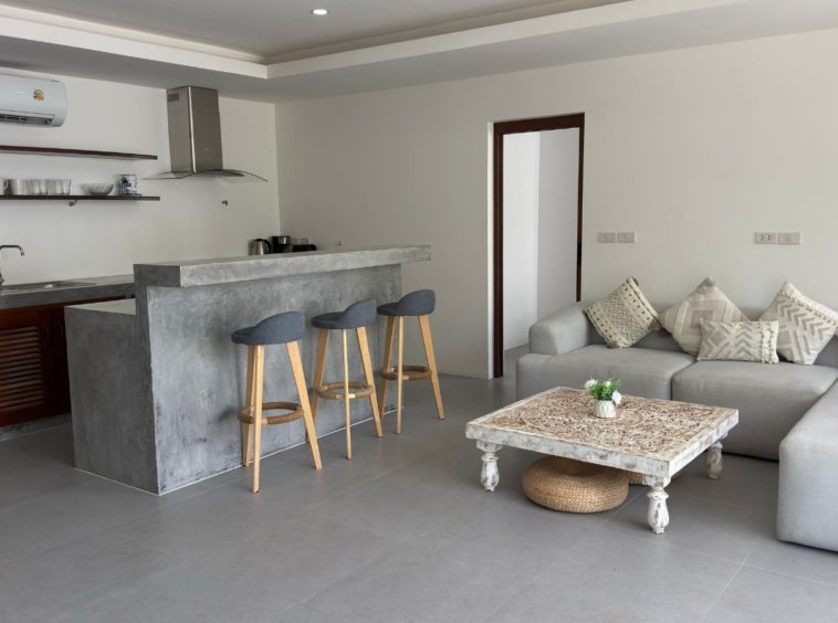Cuisine ouverte béton ciré meuble teck bar tabourets salon appartement Emerald Samui