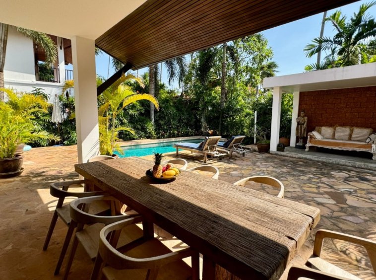 Table à manger extérieure en bois massif villa Baan Lotus bord piscine
