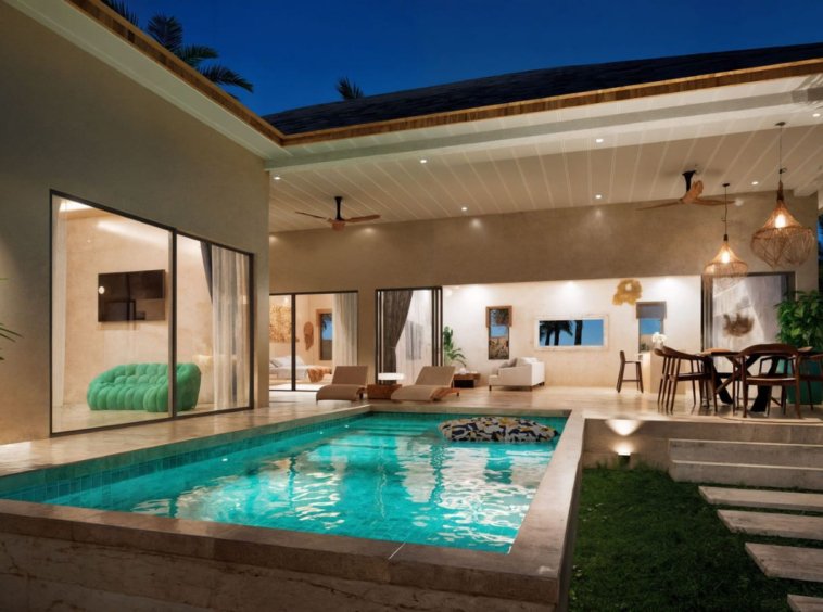 Piscine privée villa Koh Samui de nuit – eau turquoise éclairée, terrasse avec espace repas et intérieur lumineux visible en arrière-plan