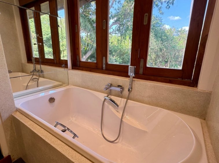 Baignoire îlot ovale fenêtre triple bois vue cimes arbres villa Koh Samui