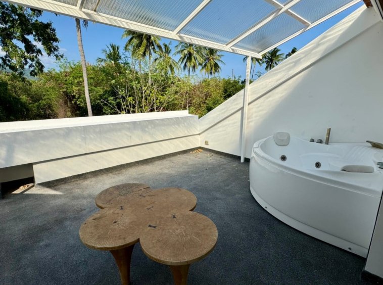 Terrasse rooftop jacuzzi extérieur table tronc bois cocotiers villa Baan Lotus