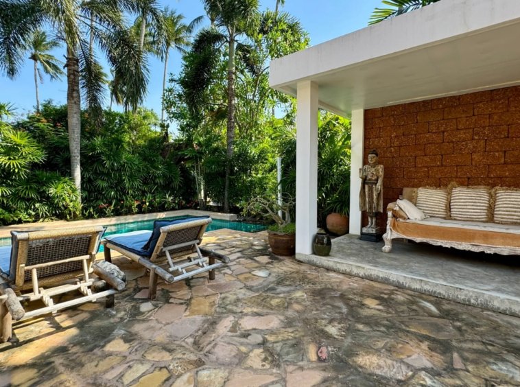 Terrasse piscine transats salon extérieur statue bouddhiste villa Baan Lotus
