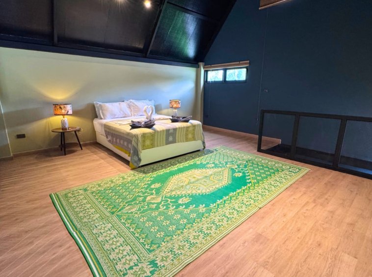 Chambre en mezzanine sous charpente de la Villa Il Segreto