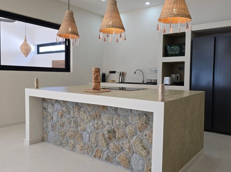 Cuisine équipée avec îlot central habillé de pierre de la Villa Ankaa