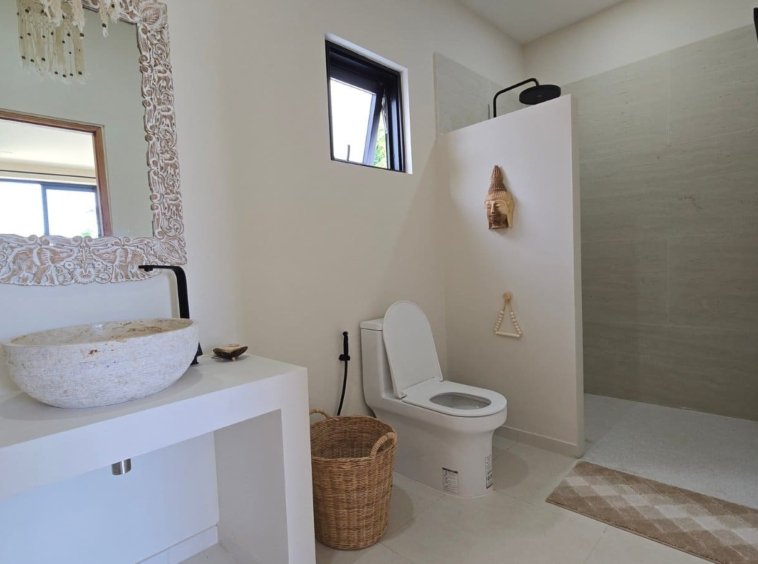Salle de bain avec vasque en pierre taillée de la Villa Ankaa