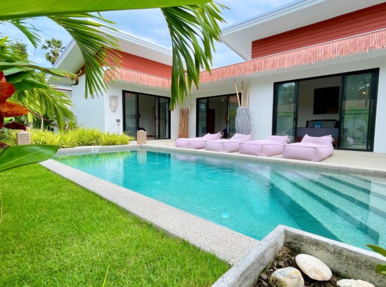 Piscine de la Villa An Se Ju entourée de pelouse et de palmiers