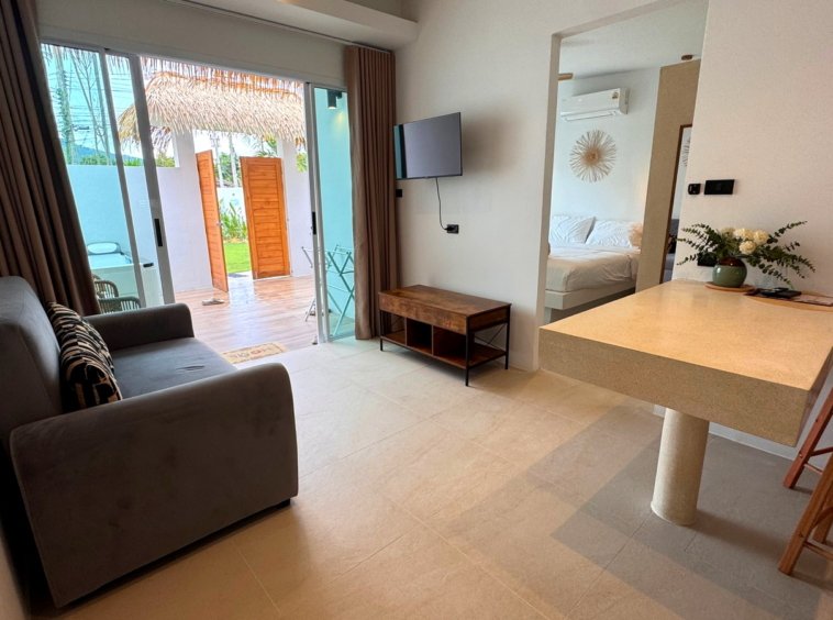 Salon avec télévision et coin repas de la villa à Maenam