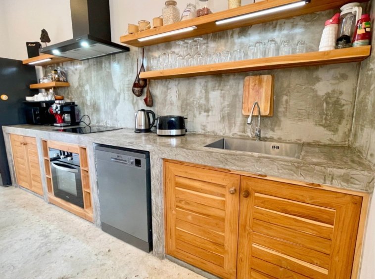 Cuisine équipée en béton ciré de la Villa An Se Ju, four et lave-vaisselle