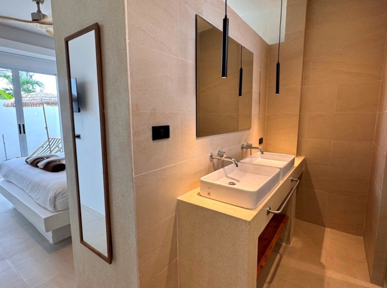 Salle d'eau avec double vasque, ouverte sur la chambre
